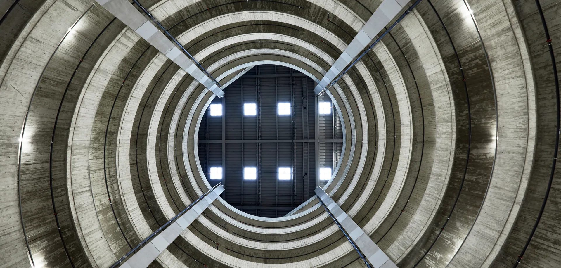 The circular concrete shaft of a construction site, photographed from below